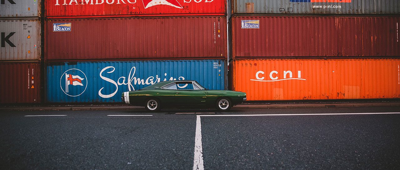 Auto voor een stapel zeecontainers in de haven